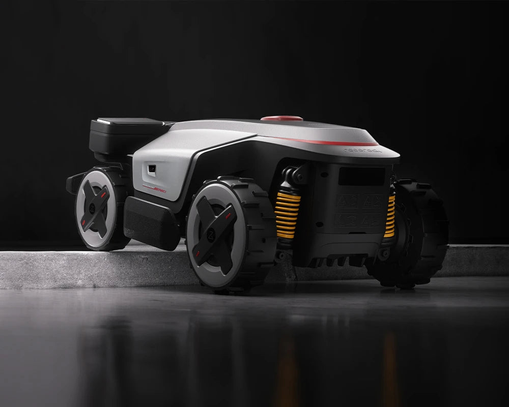 RockMow Z1 robotic lawn mower crossing a raised edge using its four-wheel drive and independent suspension.
